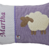 Auf dem lila Stoffmix aus Punkten und Vichykaro haben wir ein süßes Schaf aufappliziert und den Namen des Kindes gestickt.