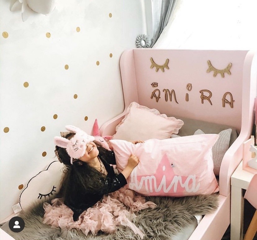 Maedchen in Kinderbett mit Namenskissen Amira